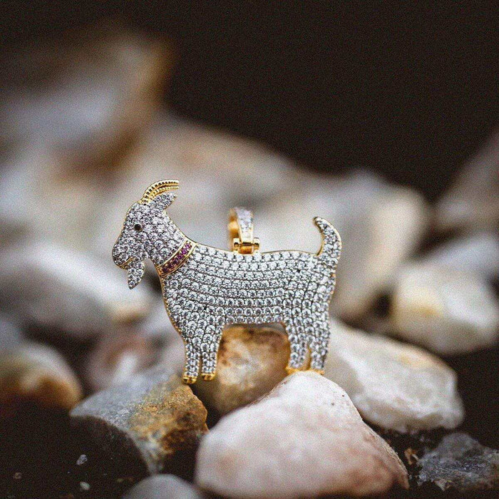 GOAT Pendant with a red collar, covered in corresponding colored CZ stones, pictured on a rocky landscape.